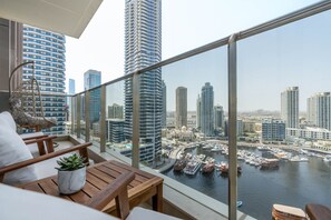 A balcony with a view of a marina and high-rise buildings. - Glamorous 1BR at Sparkle Tower (Dubai)