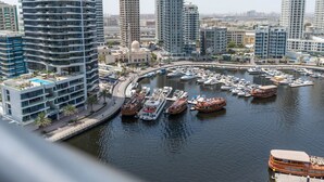 Ein Yachthafen mit mehreren angestückten Booten, umgeben von modernen Hochhäusern.