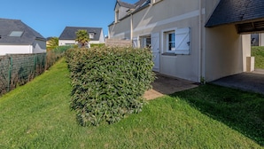 A residential area with houses, a well-maintained lawn, and a hedge. - Peaceful Coastal Stay With Access to Pool (Saint-Nic)