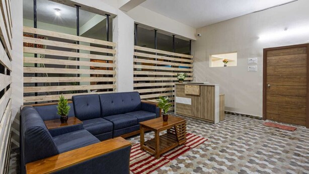 Un salon moderne avec un canapé bleu, une table basse en bois et un sol à motifs.