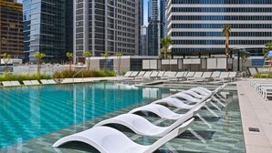 Una piscina moderna con gradinate e uno sfondo urbano.