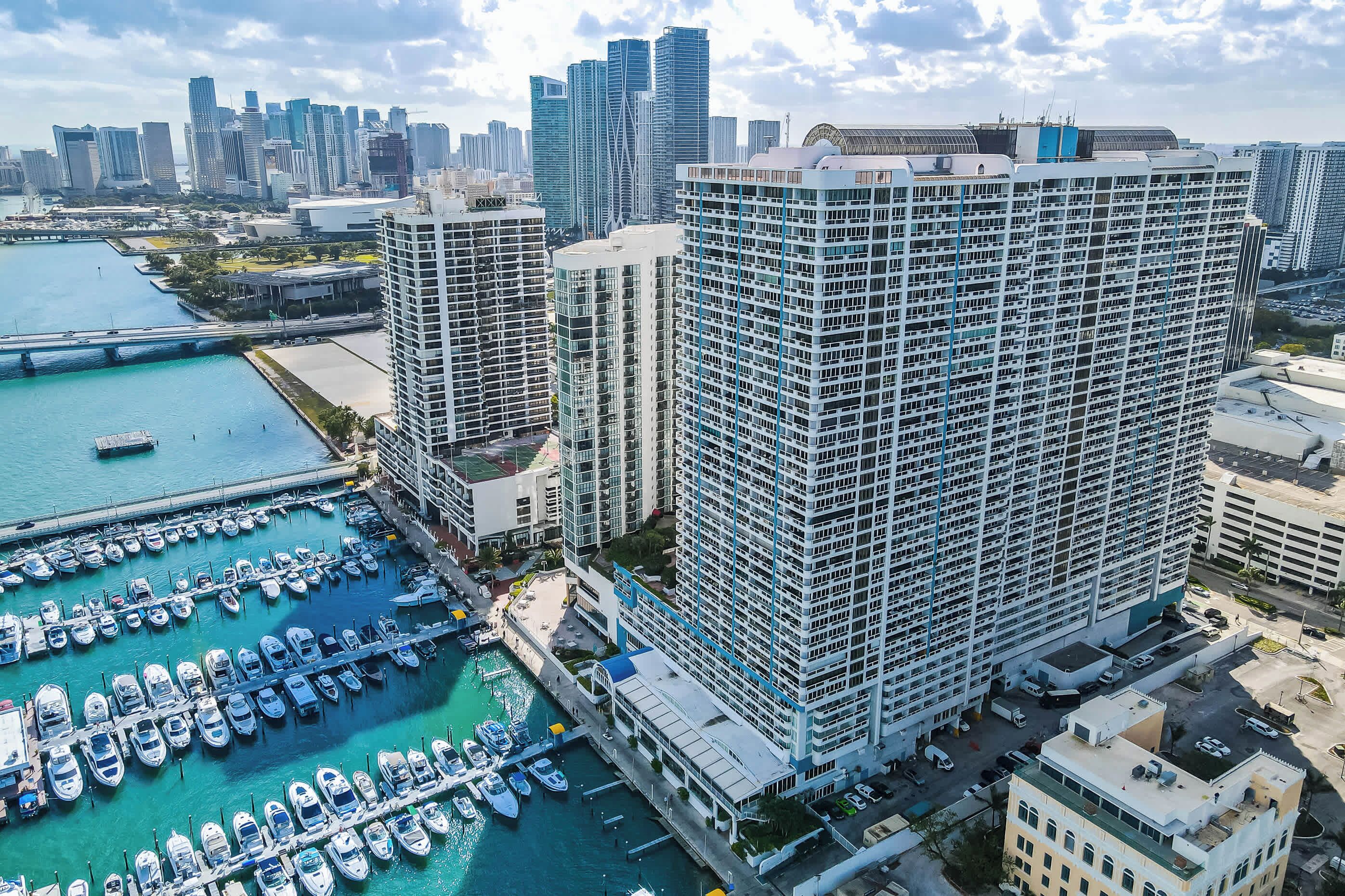 A high-rise building with a marina in the foreground.