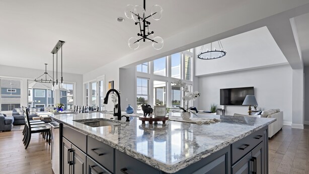 A spacious kitchen with a large island, modern appliances, and a view to the living area. - 33555 Misty Moon Drive - Large Home in The Peninsula (Millsboro)