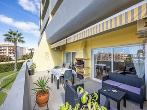 An outdoor patio with a grill, seating area, and potted plants. - Oasis do Mar - 1 bedroom apartment in Lagos (Lagos)