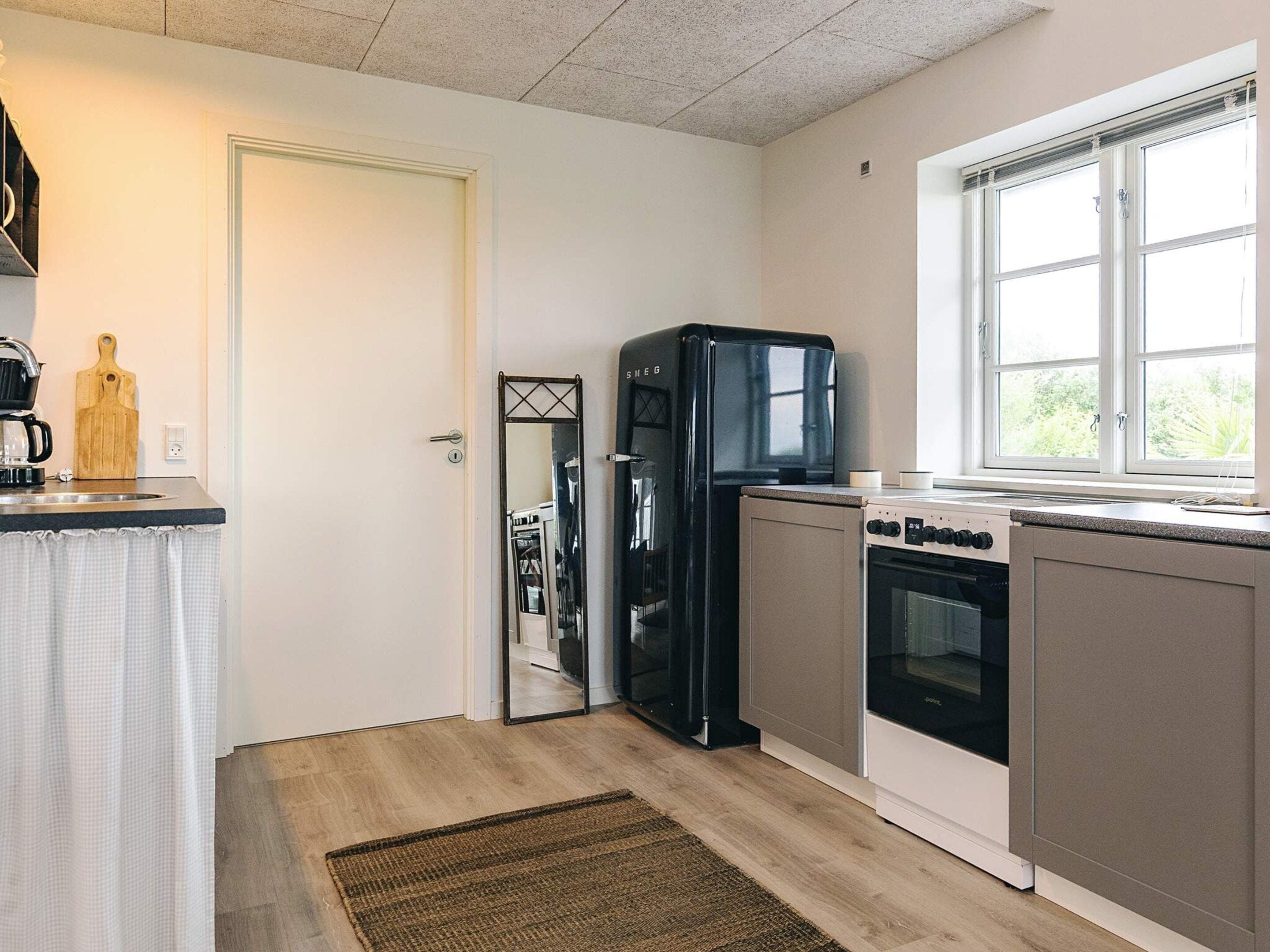A compact kitchen with a refrigerator, stove, and sink.