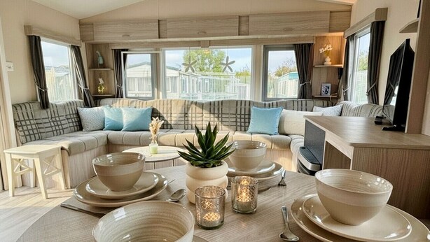 A cozy dining area with a table set for four, a sofa, and a TV in the background. - RBR 433 - Beach Resort Kamperland (Kamperland)