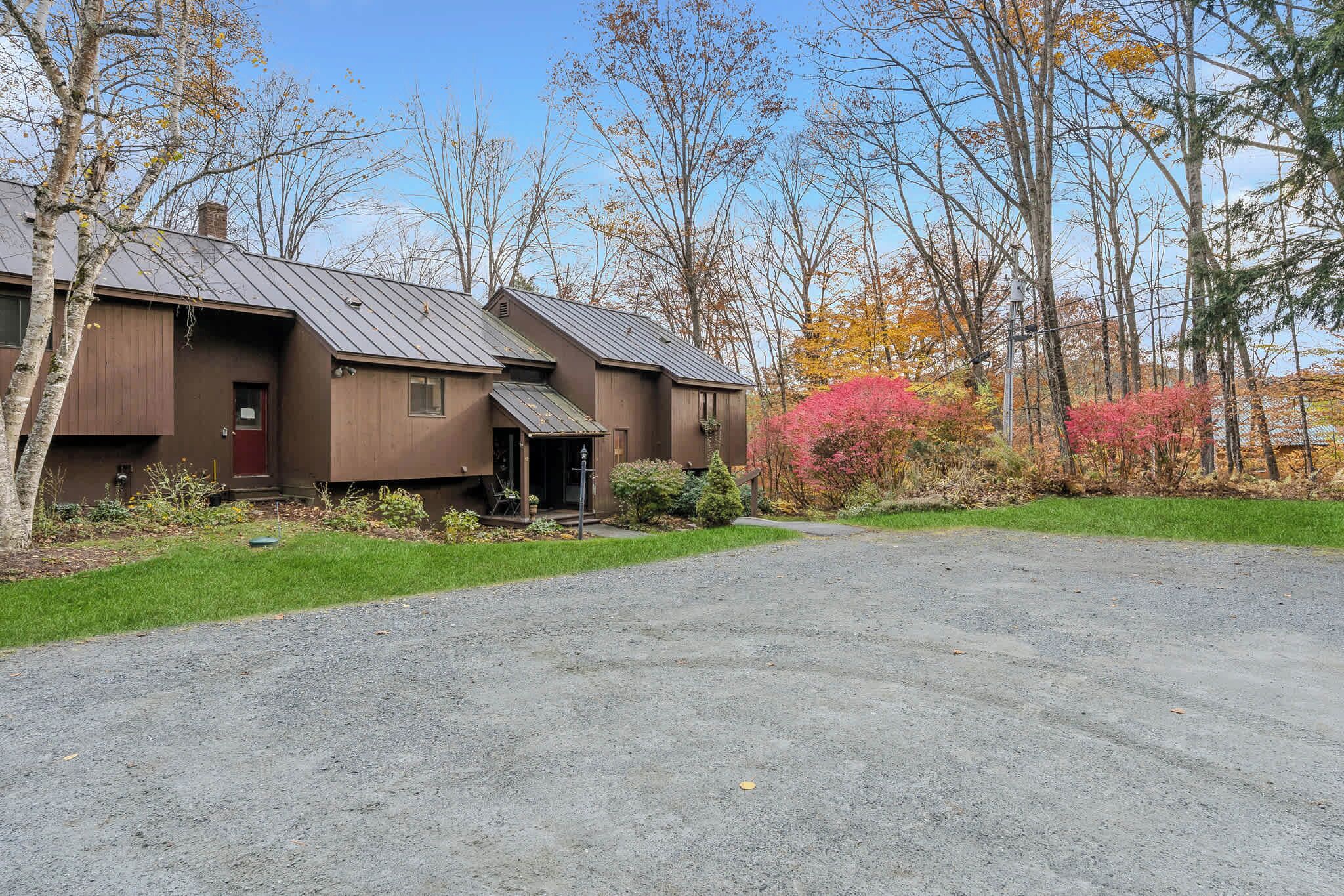 A two-story building with a metal roof, a front door, and a small porch.