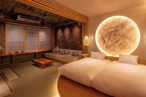 A traditional Japanese-style room with tatami flooring, a low wooden ceiling, and a large circular wall decoration.