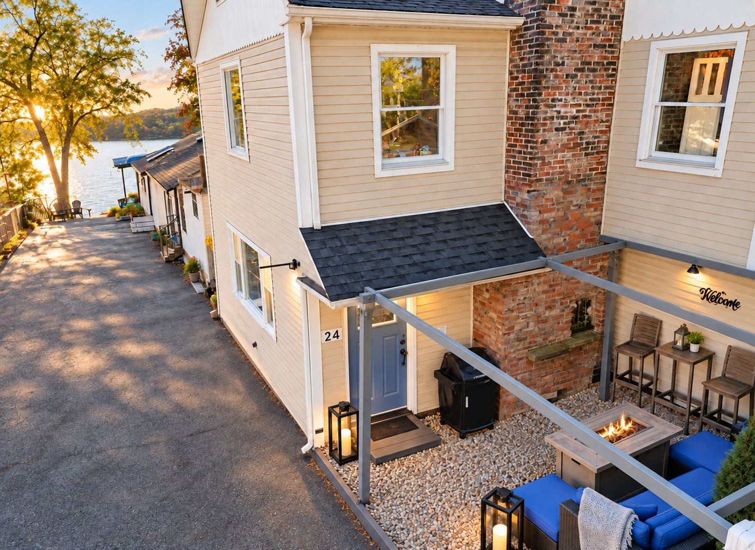 Une maison à deux étages dotée d’un patio aménagé avec des meubles d’extérieur et un foyer.