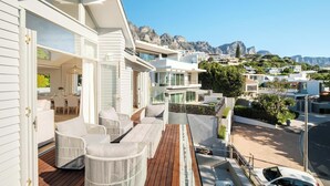 Ein modernes Wohngebäude mit einem Balkon, ausgestattet mit Korbmöbeln und einer Holzterrasse.