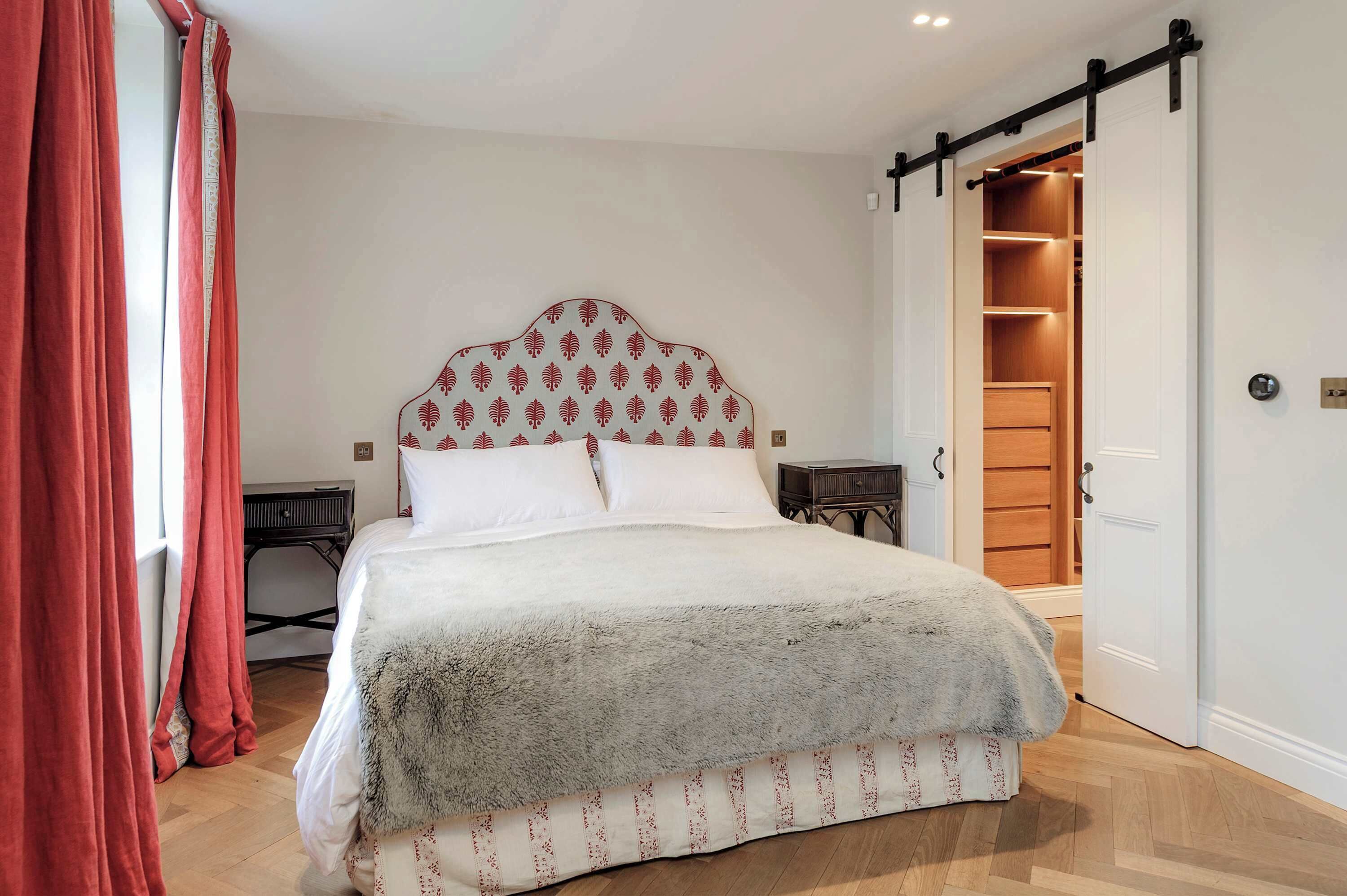 Ein Schlafzimmer mit einem großen Bett, einem Holzschrank und einem Schiebetürenschrank.