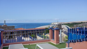 Ein Hotel mit Pool, Meerblick und einem Steinhaus mit Schornstein.