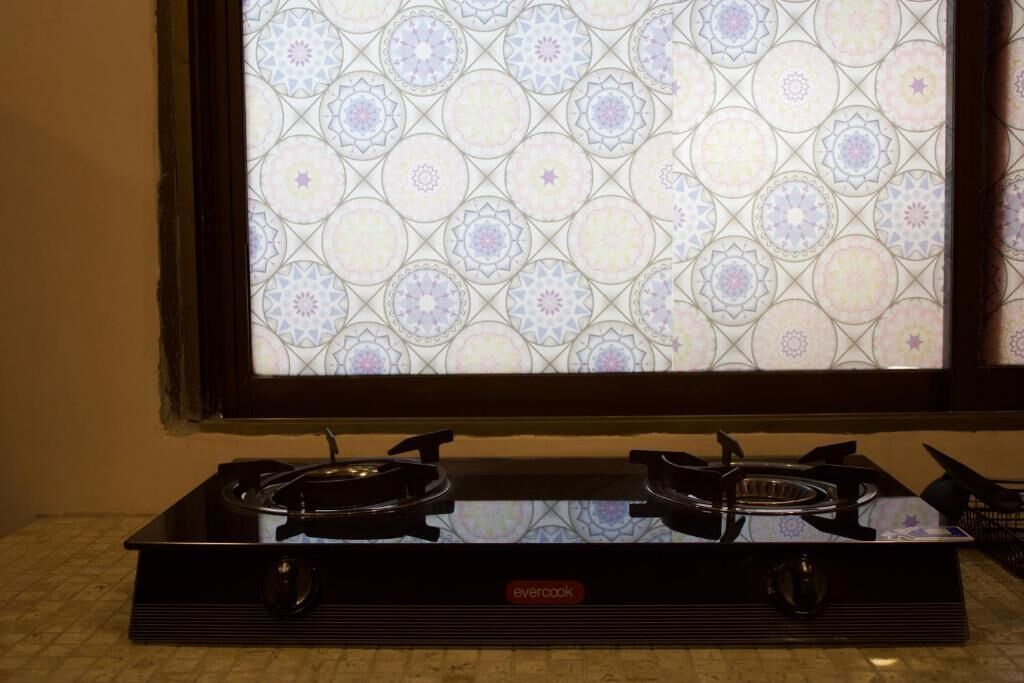 A gas stove with a patterned backsplash.
