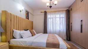Ein ordentlich eingerichtetes Schlafzimmer mit Bett, Nachttisch und Kleiderschrank.