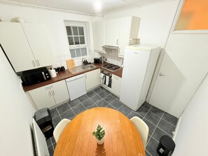 A compact kitchen with white cabinets, a wooden countertop, a stove, and a sink. - East End Escape -2 bedroom for 6ppl near Central LONDON- 3mins to DLR overground (London)