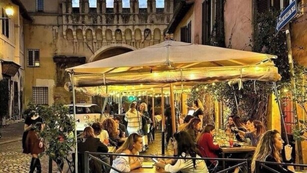 An outdoor café with tables and chairs, surrounded by cobblestone streets and historic buildings. - TRASTEVERE CAMPO de FIORI ROME by FOOT-NETFLIX-AIRCOND-WIFI (Roma)