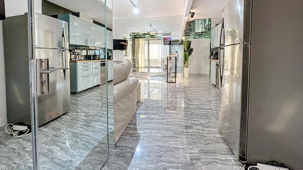 A modern kitchen with stainless steel appliances, a glass partition, and a marble floor. - Stunning 2 bed in Sadaf 6 (Dubai)
