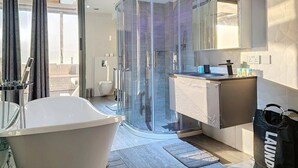A modern bathroom with a glass-enclosed shower, a freestanding bathtub, and a vanity with a mirror. - Stunning 2 bed in Sadaf 6 (Dubai)