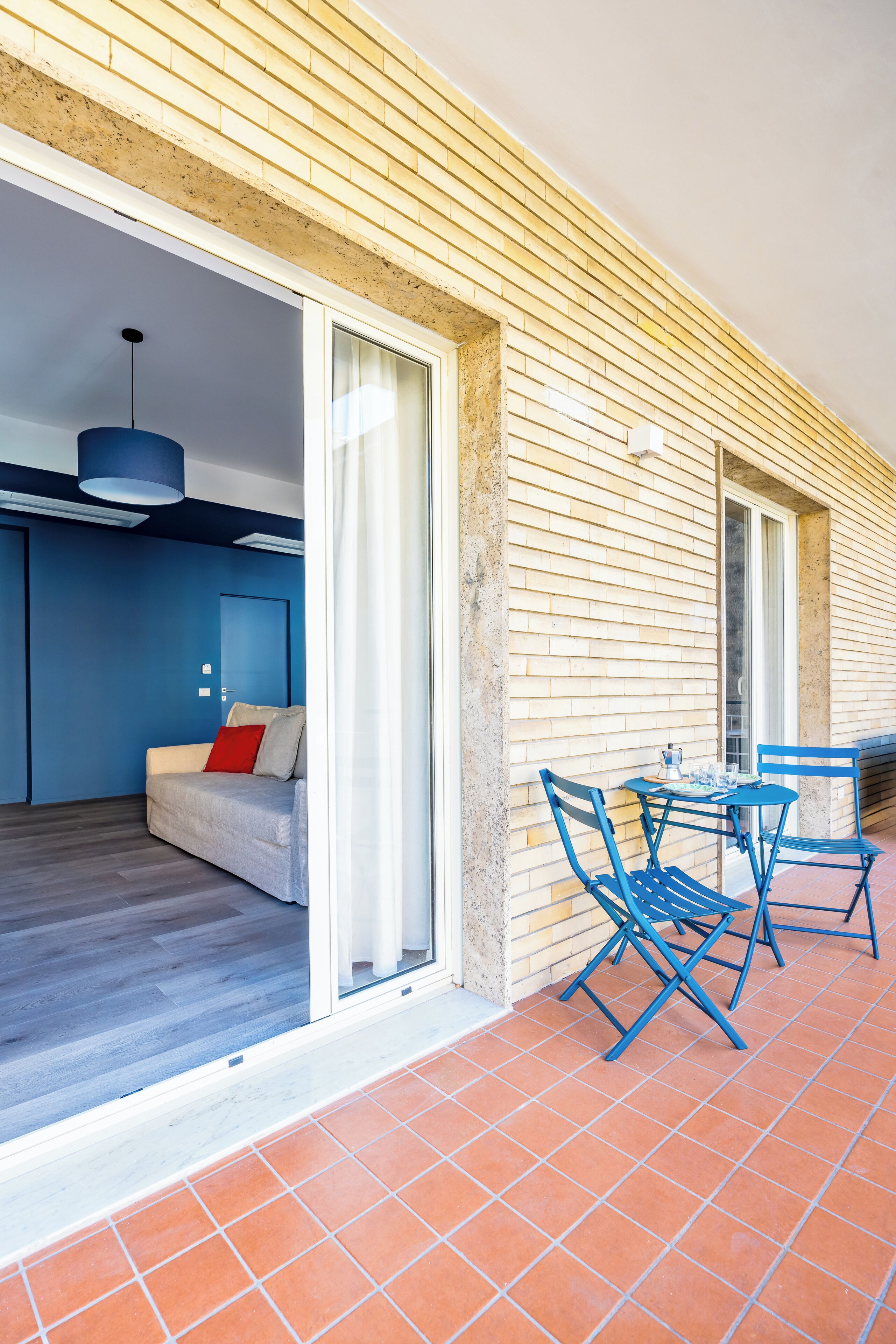 Een moderne kamer met een schuifglasdeur die uitkomt op een terras.
