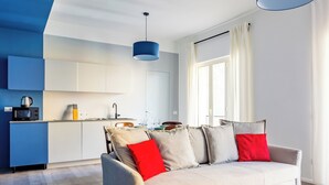 Un salon moderne comprenant un canapé, un coin repas et une cuisine.