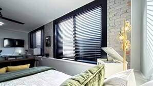 Ein modernes Schlafzimmer mit einem großen Bett, einem Schreibtisch und einem Fernseher.