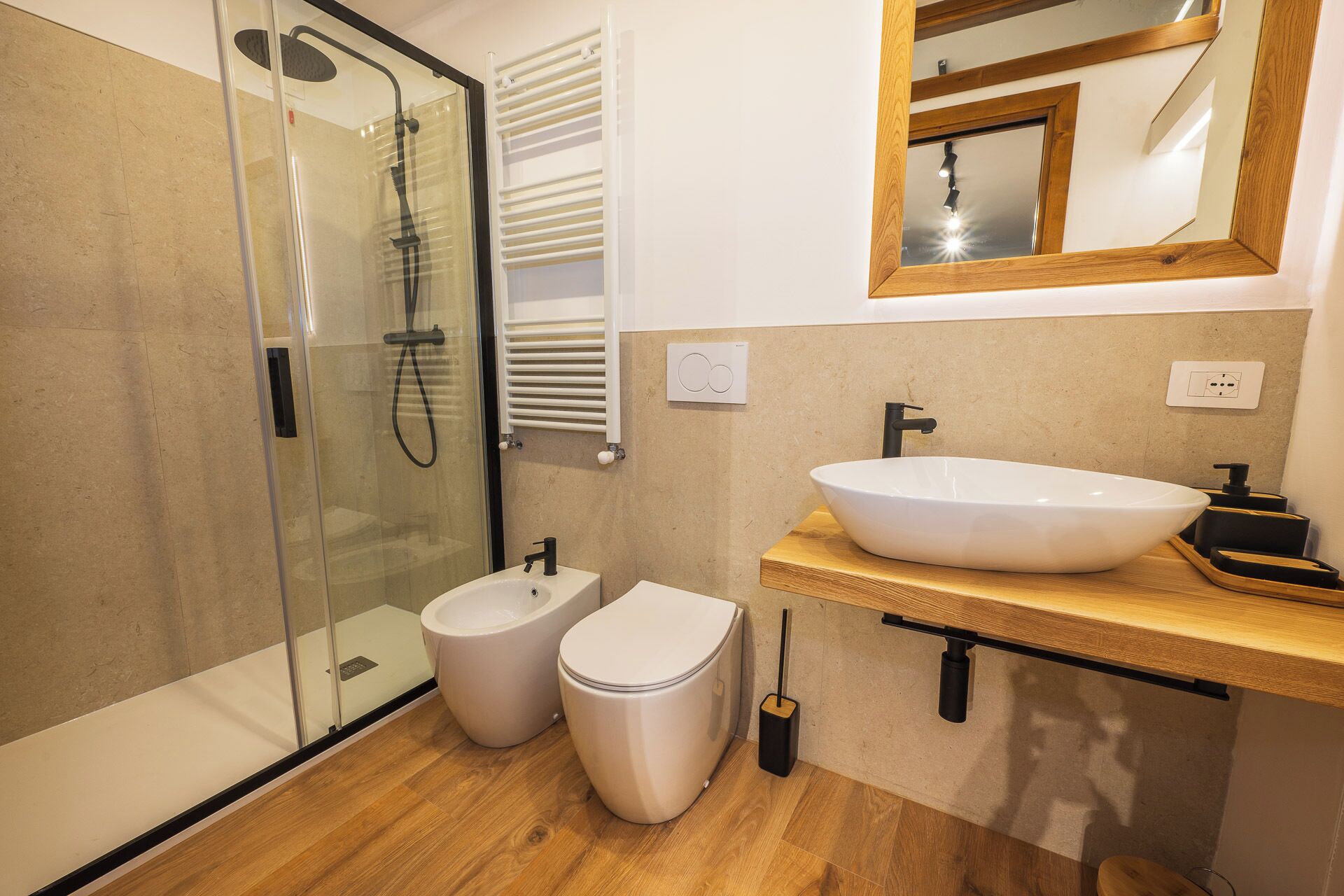 A modern bathroom with a glass-enclosed shower, a white sink, and a toilet.