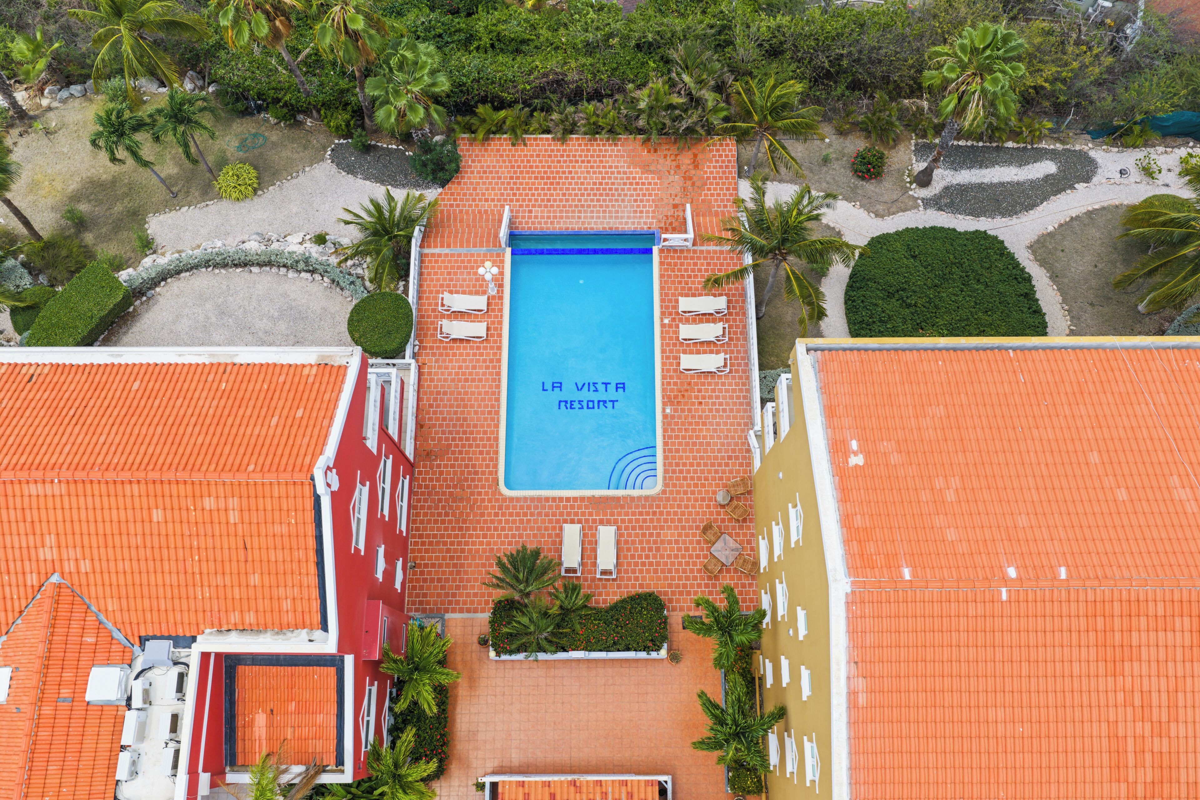 Ein Dachpool mit der Beschilderung 'LA VISTA RESORT', umgeben von Palmen und einem roten Ziegeldach.