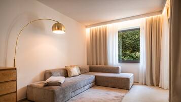 Una camera da letto moderna con un divano componibile, una lampada da terra e una finestra con tende.