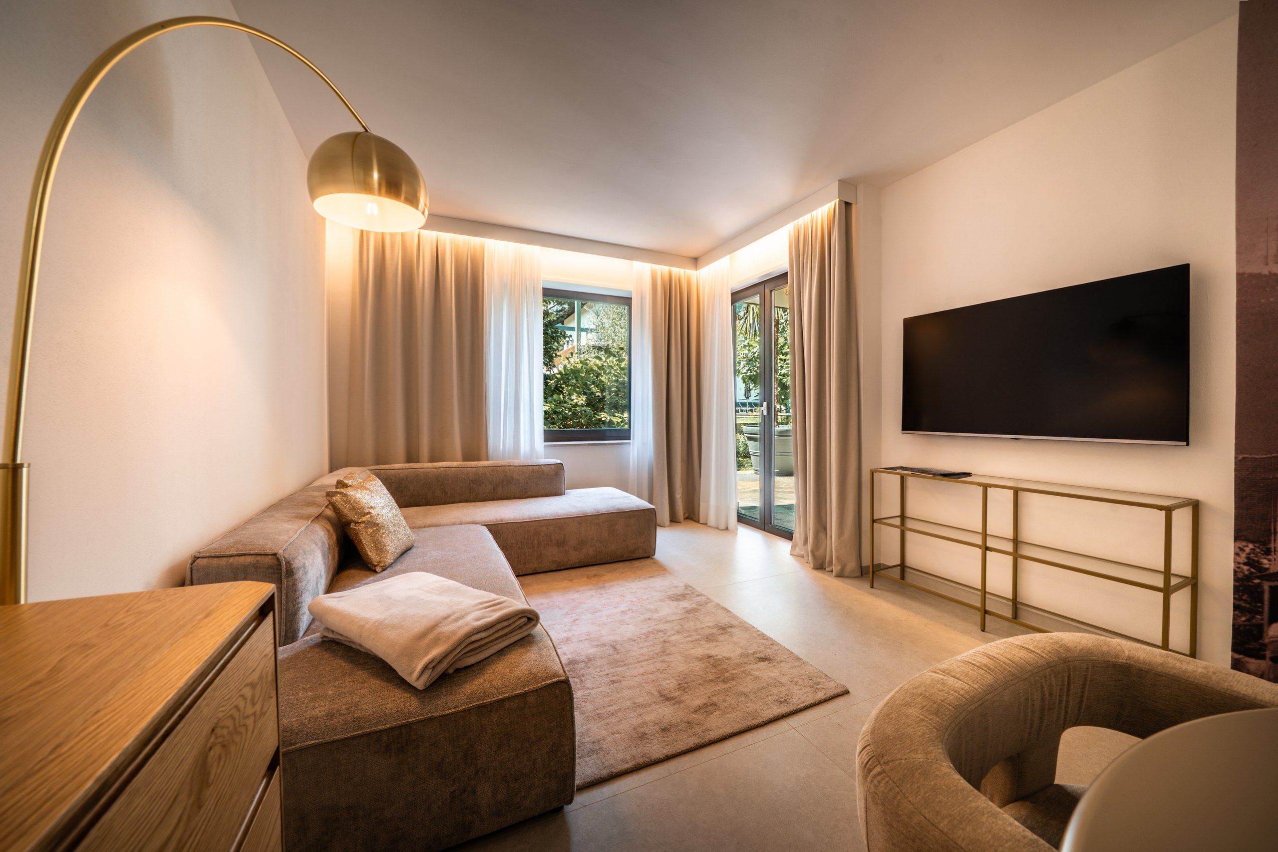 A modern living room with a sofa, a TV, and a floor lamp.