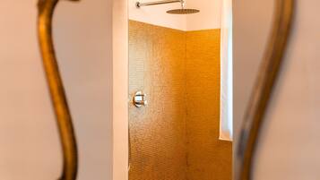 Een douche met een gebogen douchekop en een bedieningsknop.