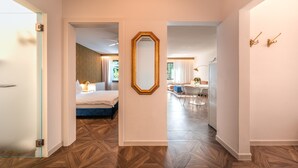 A hallway with a bed, a dining area, and a bathroom. - 739D goldfinger+suites I Apartment Individual 12 (Lana)