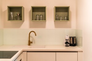 A kitchen with a sink, a coffee maker, and three glass containers on shelves. - 739G Goldfinger+Suites I Apartment Exceptional 1 (Lana)