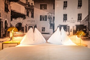 Una cama con dos almohadas blancas y dos lámparas a cada lado.