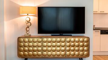 Een flatscreen-tv bevestigd aan een wand boven een houten kast met een rond ontwerp.