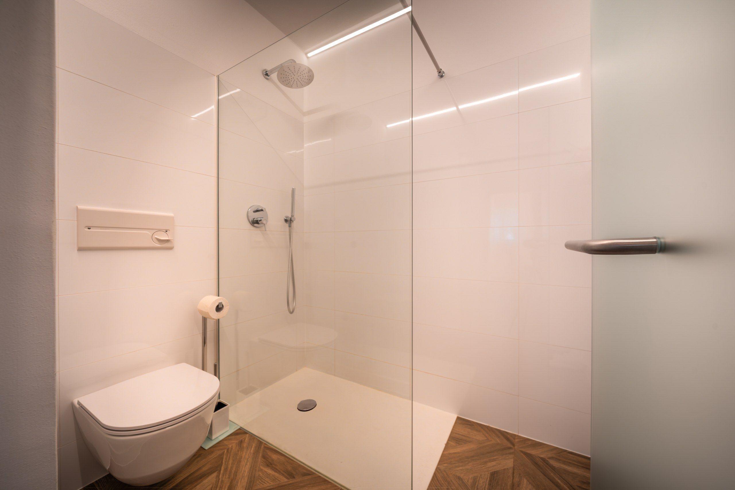 Une salle de bain moderne dotée d’une douche à parois de verre, de toilettes et d’un bidet.
