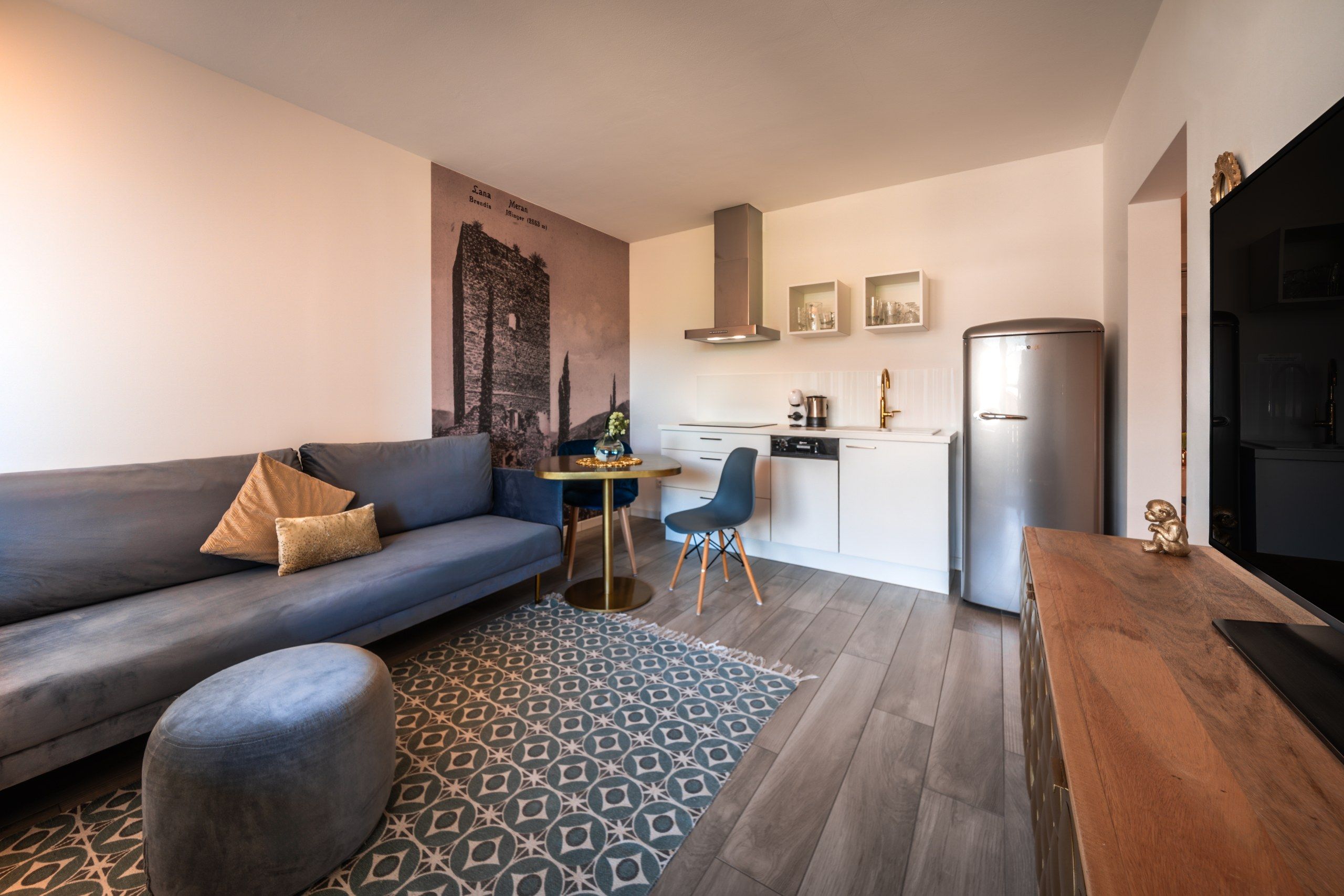Ein stilvolles Wohnzimmer mit einer Couch, einem kleinen runden Tisch und einem gemusterten Teppich.