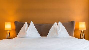 Ein Hotelzimmer mit einem Bett, zwei Nachttischlampen und einer strukturierten Wand.