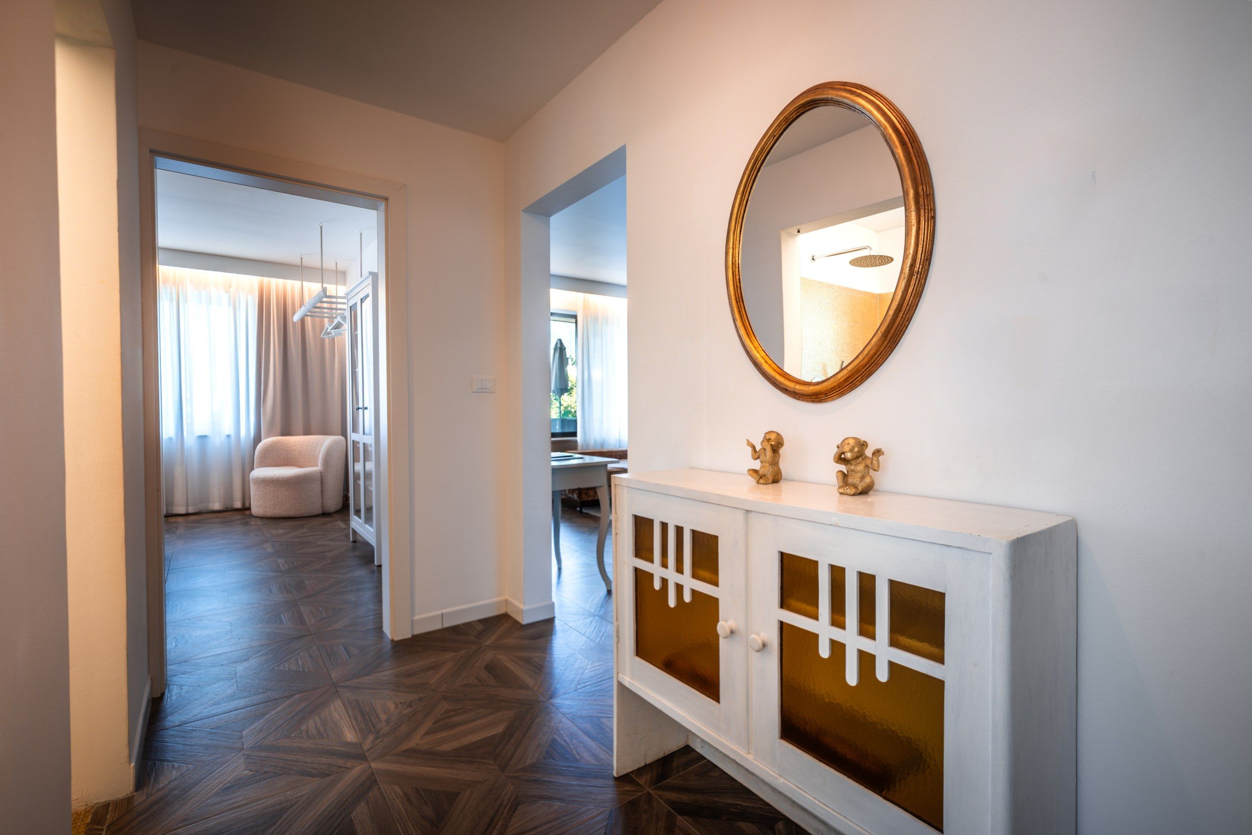 A hallway with a white console and a large mirror.