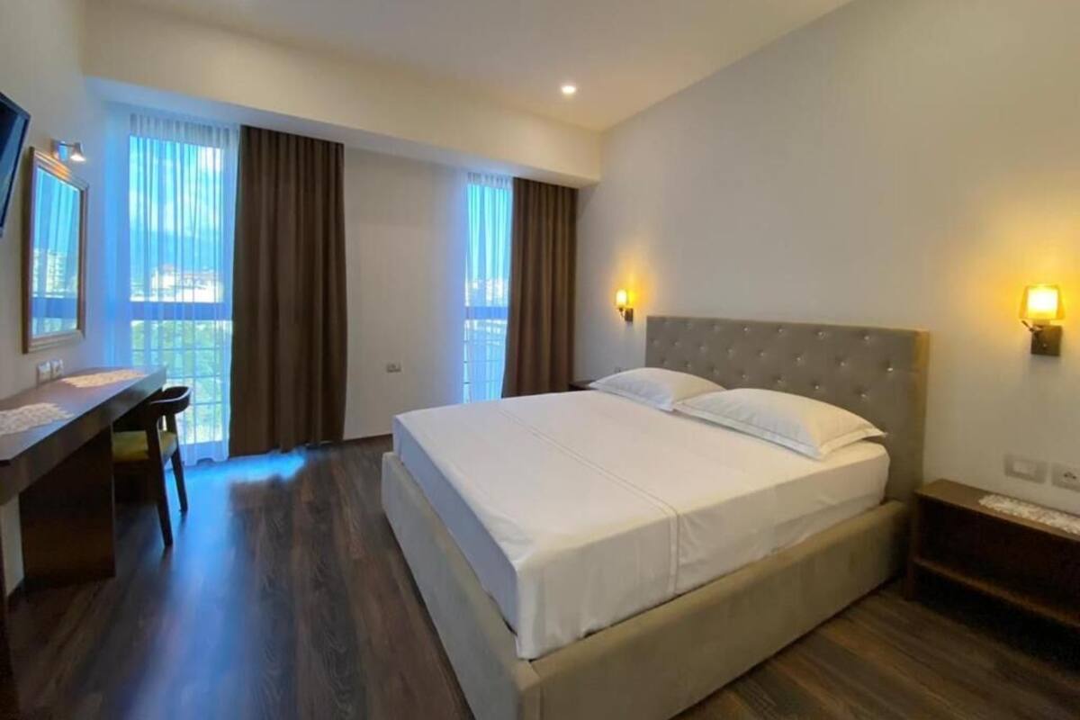Una habitación de hotel con una cama grande, un escritorio y una silla.
