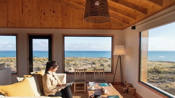 Una habitación con ventanas amplias que ofrecen vistas al mar y al paisaje desértico.