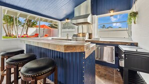 Een moderne keuken met een groot schiereiland, barstoelen en uitzicht op de omgeving.
