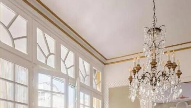 A dining room with a large table set for a meal, surrounded by chairs, a chandelier, and potted plants. - Spacious 5-bedroom apartment in charming Barcelona with AC (Barcelona)