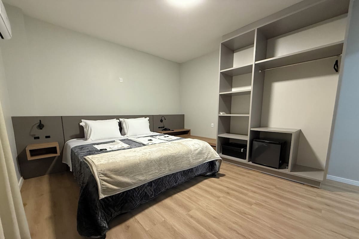 A bedroom with a bed, bedside tables, a wardrobe, and a television.