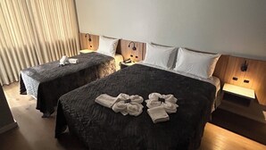 A hotel room with two beds, a wooden headboard, bedside lamps, and a large window with curtains. - Bon Vivant Hotel (Fraiburgo)