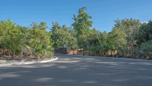 A curved road leading to a building with a stone staircase. - Peaceful Island Retreat w/ Private Patio + Parking (Leeward Settlement)