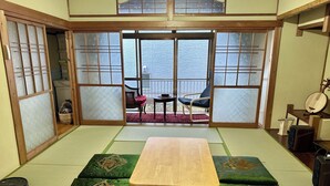 A tatami mat room with a wooden table, green cushions, a view of the sea, and traditional Japanese furniture. - One building for rent. Fujigaoka is a 15-minute walk and Ghibli Park is a 20-minute drive. 2 parking spaces. Convenience store and supermarket within walking distance. Ideal for families and pets. (名古屋市守山区森孝東)