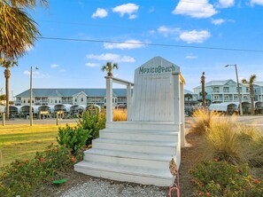 A sign for Mexico Beach, Florida, with a staircase leading up to it. - Beach House - C Shucker by PHG (Mexico Beach)