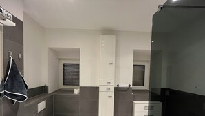 A modern bathroom with a toilet, sink, and shower area. - Quiet & close to the city (Chemnitz)