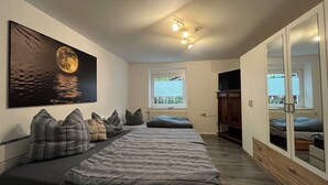 A bedroom with a bed, a painting of a moon, a window, and a wardrobe. - Quiet & close to the city (Chemnitz)