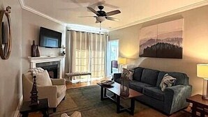 A living room with a fireplace, a sofa, a coffee table, and a television. - KLTA6  Beach to Beech Villa  2 BR/2 BA Condo Walking distance to Town (Beech Mountain)